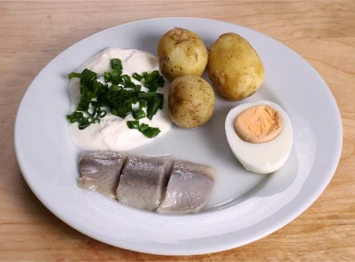 Pickled herring and potatoes on a plate